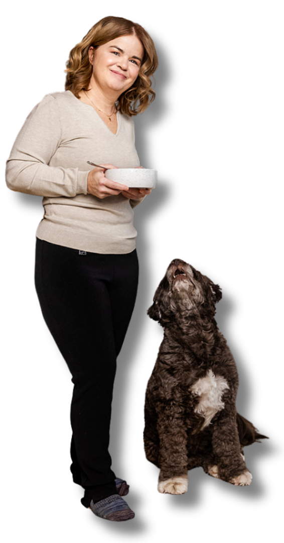 Karine avec un bol de nourriture et son chien à ses côtés