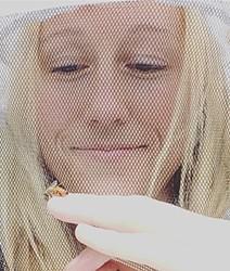 female beekeeper looking at a bee