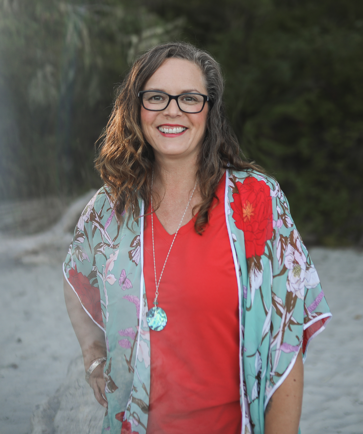 spa business coach standing on the beach smiling